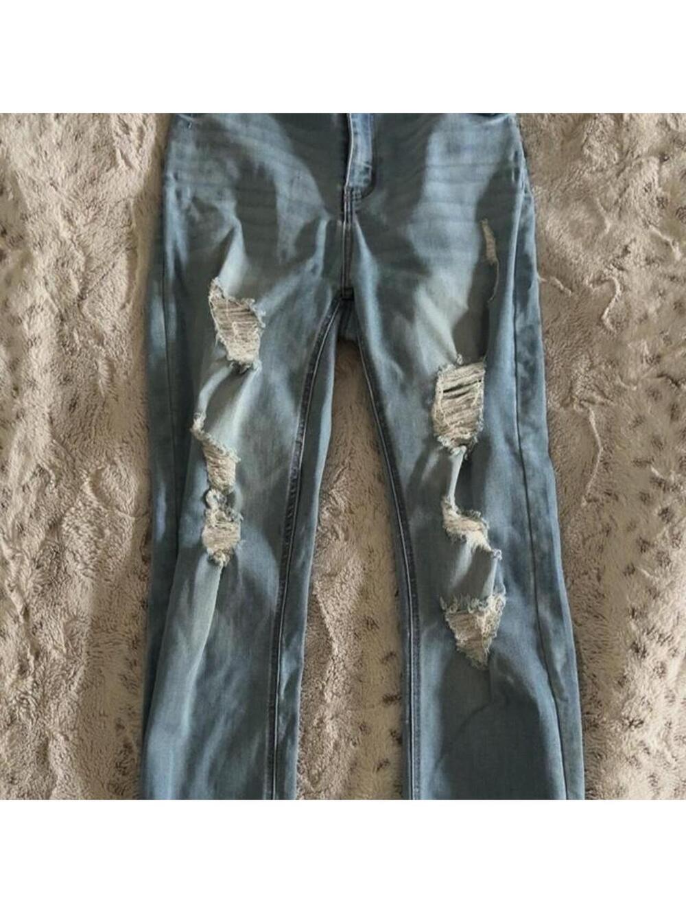 light blue denim elite jeans with ripped details and cuffed leg